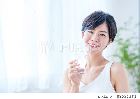 窓際で水を飲む女性 88555381