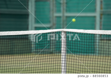 硬式テニスの試合中のテニスコートのネットとテニスボール 88560853