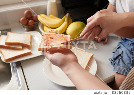 Mother and Son Spreading Bread 88560885