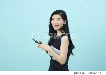 Surprised young Asia lady using mobile phone with positive expre 88564515