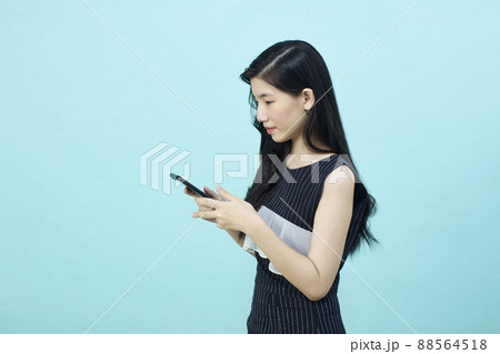 Surprised young Asia lady using mobile phone with positive expre Surprised young Asia lady using mobile phone with positive expre 88564518