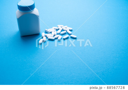 White pills on a blue background close-up. 88567728