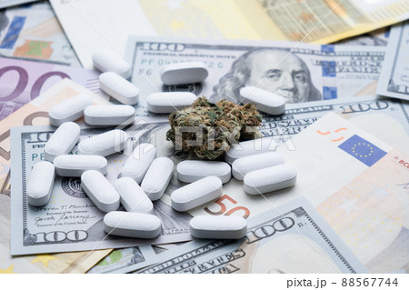 Cannabis marijuana and narcotic pills on the background of the dollar close-up. Cannabis marijuana and narcotic pills on the background of the dollar close-up. 88567744