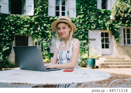 Positive female freelancer working on computer in morning 88571318