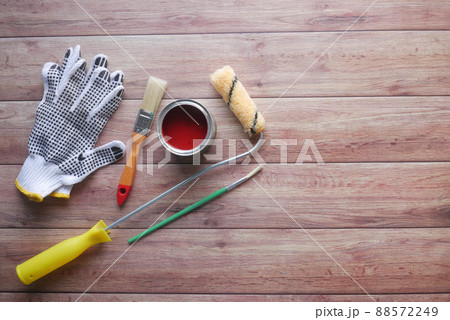 A paint brush , gloves and paint on table A paint brush , gloves and paint on table 88572249