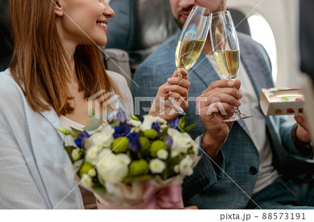Couple in love toasting with champagne glasses in airplane 88573191