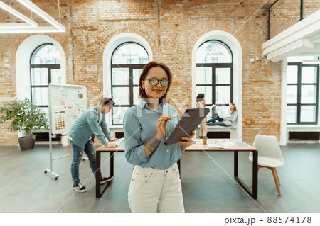 Portrait of happy woman with tablet in office. 88574178