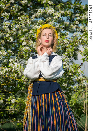 Beautiful feminime woman in national dress with white spring flowers Beautiful feminime woman in national dress with white spring flowers 88575205