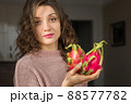 Young girl is holding two fresh ripe organic dragon fruits or pitaya, pitahaya. Exotic fruits, healthy eating concept 88577782