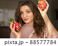Young girl is holding two fresh ripe organic dragon fruits or pitaya, pitahaya. Exotic fruits, healthy eating concept 88577784