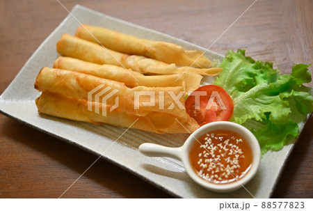 Chinese spring rolls fried with chili sauce and white sesame in a ceramic plate Chinese spring rolls fried with chili sauce and white sesame in a ceramic plate 88577823