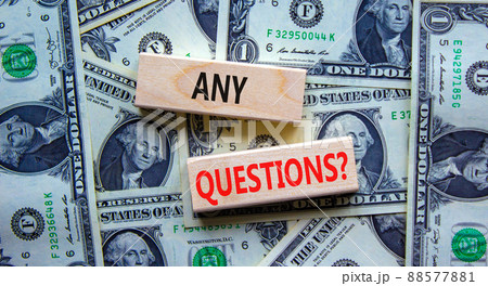 Any questions symbol. Concept words Any questions on wooden blocks on a beautiful background from dollar bills. Business and Any questions Q and A concept, copy space. 88577881
