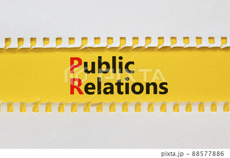 PR public relations symbol. Concept words PR public relations on yellow paper on a beautiful yellow table white background, copy space. Business and PR public relations concept. 88577886