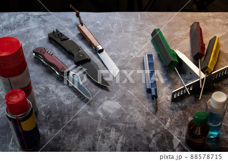 Several knives are on the table. Various knives on the table. Knives and tools on the table. Knife workshop. 88578715