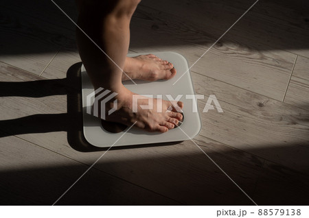Close-up of female legs on electronic scales. Close-up of female legs on electronic scales. 88579138