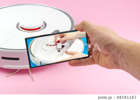 white robot vacuum cleaner on a pink background. The procedure for cleaning the robot vacuum cleaner after cleaning. future home technology. 88581167