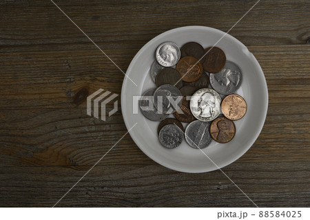 small American coins on a white porcelain saucer 88584025