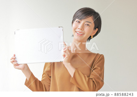 メッセージボードを掲げ顔を傾ける女性1 メッセージボードを掲げ顔を傾ける女性1 88588243