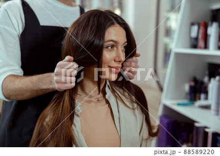 Portrait of salon female customer looking happy while doing hairstyle Portrait of salon female customer looking happy while doing hairstyle 88589220