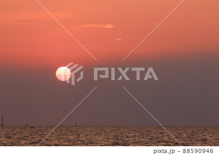 The landscape on a clear sky day will see a beautiful sunset slowly sliding down above the sea surface. It's a beautiful sight to see. 88590946