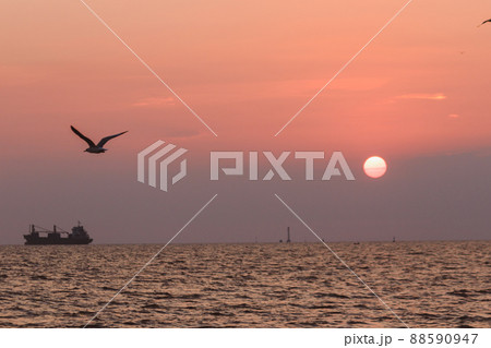 The landscape on a clear sky day will see a beautiful sunset slowly sliding down above the sea surface. It's a beautiful sight to see. The landscape on a clear sky day will see a beautiful sunset slowly sliding down above the sea surface. It's a beautiful sight to see. 88590947