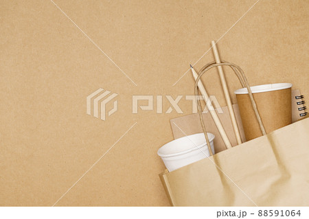 Eco friendly concept, notebook pencil and paper cup with straws in paper bag on wooden background Eco friendly concept, notebook pencil and paper cup with straws in paper bag on wooden background 88591064