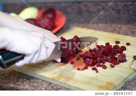 Woman housewife cutting beets into cubes for salad closeup 88591547