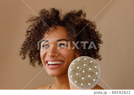 Happy lady representing cosmetic tool in studio 88592822