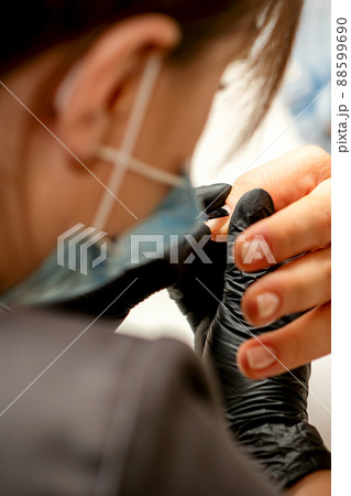 Manicure painting process. Manicure master paint the nails with transparent varnish in a nail salon, close up Manicure painting process. Manicure master paint the nails with transparent varnish in a nail salon, close up 88599690