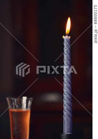Still life with a glass of pink champagne and a burning candle. Vertical photo. 88600175