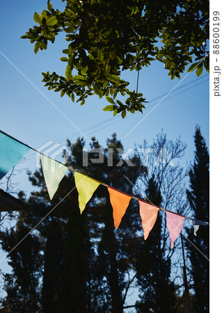 Festive fabric garlands against the blue sky in summer. The concept of celebration, rest, joy and happiness. Vertical photo. Festive fabric garlands against the blue sky in summer. The concept of celebration, rest, joy and happiness. Vertical photo. 88600199