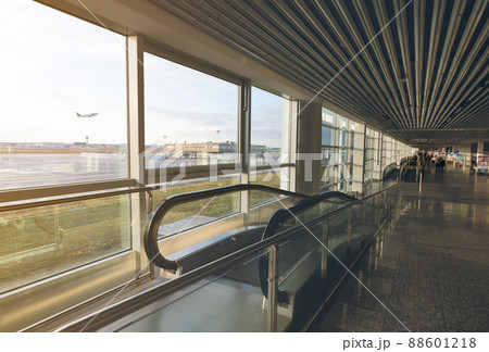 Escalator inside international airport terminal on blurred passenger walking in the airport. Airport building with glass window. Escalator for passenger fast movement in the airport. Travel concept. 88601218