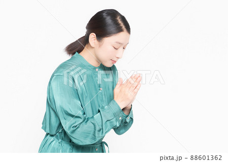 白い背景の前で掌を合わせてお願いする主婦 88601362