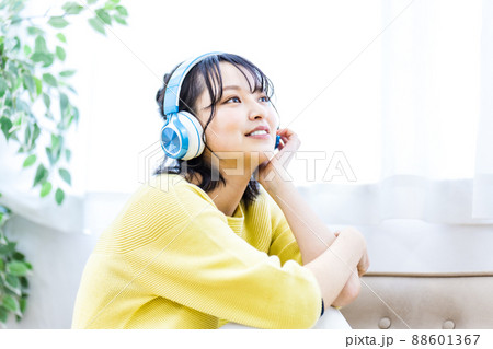 ヘッドフォンで音楽に聴き入る若い女性 88601367