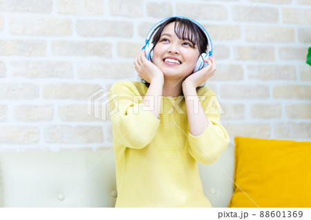 ヘッドフォンで音楽に聴き入る若い女性 88601369