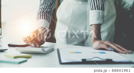 Consult financial concept. Business woman using calculator and pointing at papwework and using laptop computer. Consult financial concept. Business woman using calculator and pointing at papwework and using laptop computer. 88601961