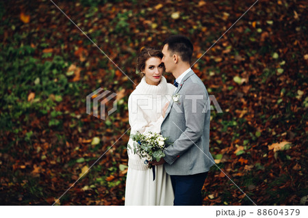 Groom and bride posing at autumn forest, among 88604379