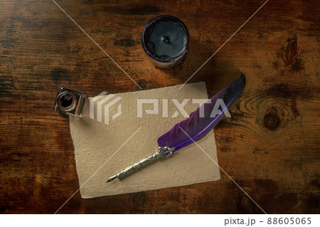 Feather quill pen with a vintage inkwell and old parchment paper Feather quill pen with a vintage inkwell and old parchment paper 88605065