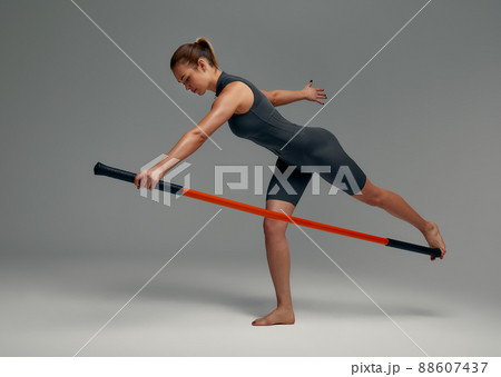 beautiful girl in sports uniform is training kung fu in the studio, fighter athlete, practicing martial arts with a stick beautiful girl in sports uniform is training kung fu in the studio, fighter athlete, practicing martial arts with a stick 88607437