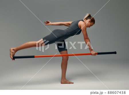 beautiful girl in sports uniform is training kung fu in the studio, fighter athlete, practicing martial arts with a stick beautiful girl in sports uniform is training kung fu in the studio, fighter athlete, practicing martial arts with a stick 88607438
