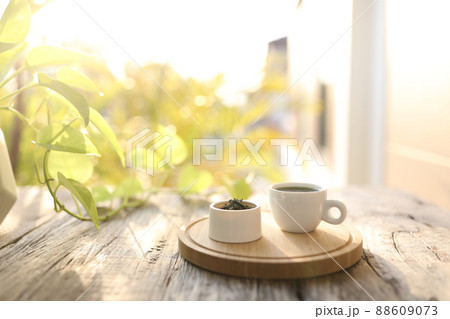 Tea cup and tea pot and green leaves on wooden table Tea cup and tea pot and green leaves on wooden table 88609073