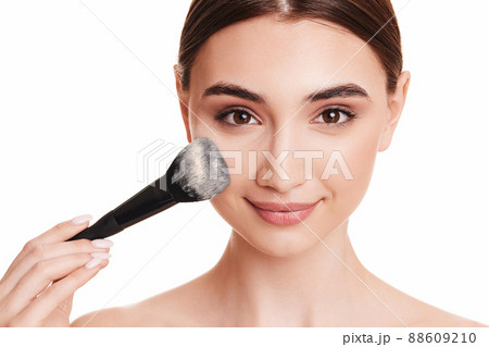woman applying powder with make up brush woman applying powder with make up brush 88609210