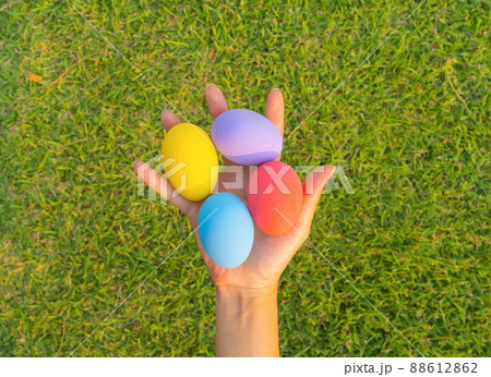 Hands of people holding colorful easter eggs on natural green grass background. Food decoration on holiday. Hands of people holding colorful easter eggs on natural green grass background. Food decoration on holiday. 88612862