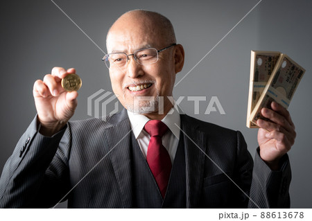 札束と仮想通貨をもつシニア男性 札束と仮想通貨をもつシニア男性 88613678