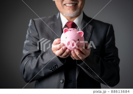 貯金箱を持つシニア男性の手元 88613684