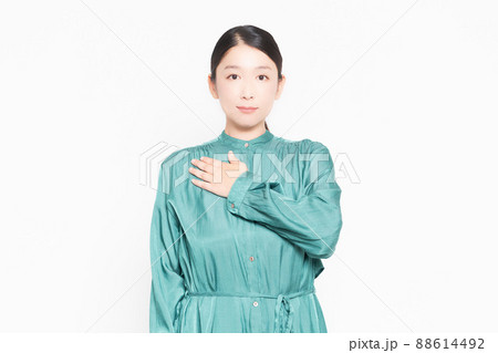 白背景の前で胸に手を当てる主婦 88614492