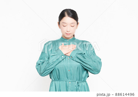 白背景の前で胸に手を当てる主婦 白背景の前で胸に手を当てる主婦 88614496