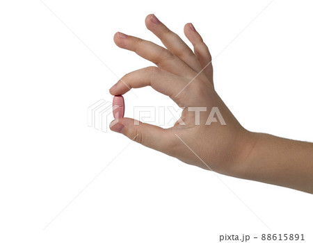 Demonstration of a pill between the fingers of the hand. 88615891