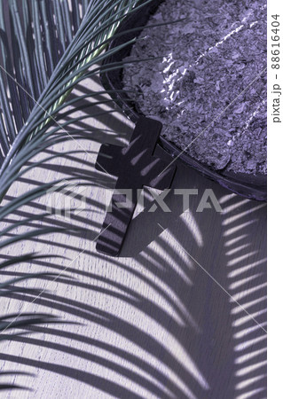 A Christian cross with palm leaf shadow on ashes background. Lent Season, Holy Week and Good Friday concept.  88616404