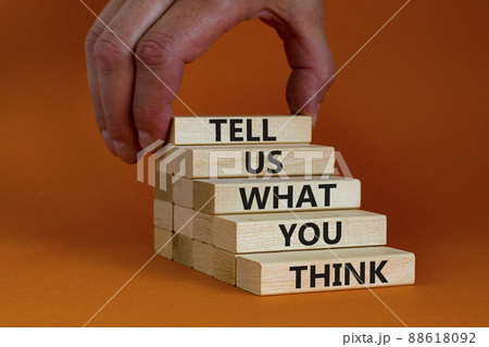 Symbol of building success and support foundation. Wooden blocks with words 'tell us what you think'. Beautiful orange background, copy space. Businessman hand. Business, support concept. 88618092